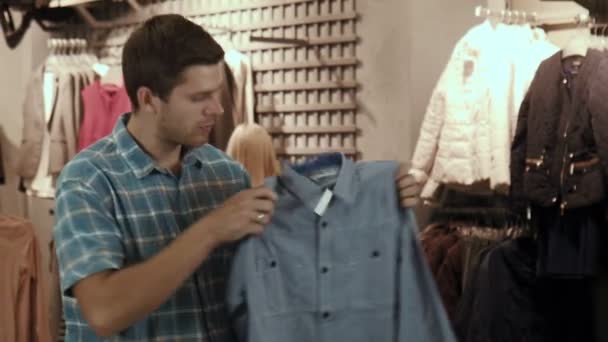 The guy tries on a shirt — Stock Video