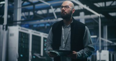 Dijital Tablet 'te Mühendis Kontrol Sistemi Ölçümleri. Kara Yelek ve Gözlüklü Bilişim Mühendisi Sunucu Rafları Arasındaki Dijital Tablet 'te Sistem Ölçümleri. Bulut Denetleme ve Teknik Analiz.