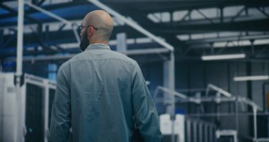 Mühendis Teknoloji Merkezi 'nden geçiyor. Sakallı Profesyonel Yürüyüş Büyük Teknoloji Merkezi 'nin Parlak Işık Salonu' nda. Yüksek Teknoloji Çalışma Ortamı ve Bakım Turları.