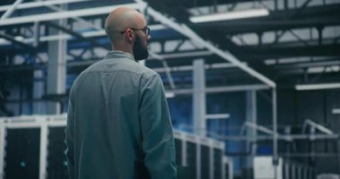 Mühendis Teknoloji Merkezi 'nden geçiyor. Sakallı Profesyonel Yürüyüş Büyük Teknoloji Merkezi 'nin Parlak Işık Salonu' nda. Yüksek Teknoloji Çalışma Ortamı ve Bakım Turları.