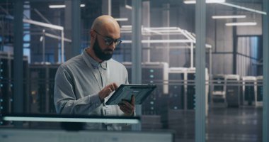 Site Koordinasyonunda, Bilgi İşlem Uzmanı Tablet kullanarak Rack Statüsünü Tanılıyor. Mobil Tablet Aygıtı kullanarak odaklanmış IT Professional Diagnoses Sunucu Rafı Durumu. Koordinasyon ve Sitede Sorun Çıkarma.