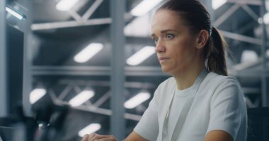 Sistem İzleme İş İstasyonuna Odaklanan Bayan Bilişim Mühendisi. Arka plan Mavi Edebiyat, Veri Merkezi Kontrol Odası Yüksek Teknoloji Ortamı. Kritik Analiz ve Profesyonel Adanmışlık.