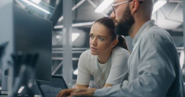 Mühendisler Ağ Performans Verilerini İnceledi. Erkek ve Kadın Bilişim Mühendisleri Ekibi Kritik Ağ Performans Ölçülerini İncelemek İçin Bilgisayar Monitörü Üzerinde İşbirliği Yapıyor. Takım çalışması ve Gerçek zamanlı IT İzleme.