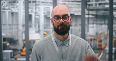 Adanmış Erkek Teknik Uzman Otomatik Endüstriyel Sanayi Santralinin önünde kendinden emin bir şekilde pozisyon alıyor. Robotik ve Gelişmiş Üretim Sürecinde Robot Yönetimi Konsepti. Portre.