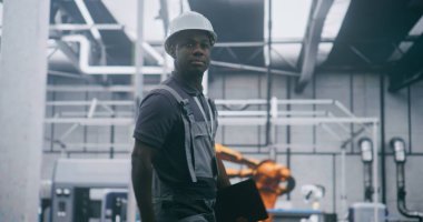 Elde Tablet, İnceleme Üretim Sistemleri, Robotik Kurul Hatlarını Denetleme ve Modern Akıllı Fabrika Verimliliğinin Sağlanması ile Profesyonel Sanayi Yöneticisi Çalışıyor.