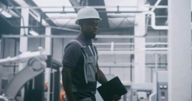 Elde Tablet, İnceleme Üretim Sistemleri, Robotik Kurul Hatlarını Denetleme ve Modern Akıllı Fabrika Verimliliğinin Sağlanması ile Profesyonel Sanayi Yöneticisi Çalışıyor.