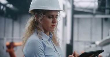 Hard Hat Giyen ve Robotik Silahlarla Modern Otomatik Fabrika İçinde Yapım Verilerini Denetleyen Kadın Endüstriyel Mühendisin Kapanışı. Akıllı Üretim ve Sanayi 4.0 Konsepti.