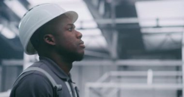 Koruyucu Teçhizatta Yakın Adam Santral Operasyonlarına Odaklandı. İş üniformalı fabrika işçisi ve sert şapkalı. Güvenlik ve Dikkat kavramı, Güvenlik Protokolleri ve Endüstriyel Operasyonlara Yoğun Odaklanma.