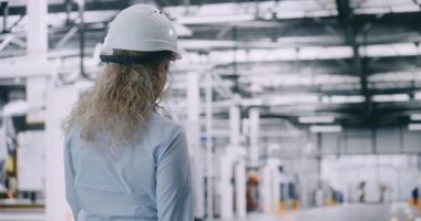 Beyaz Şapkalı Kıvırcık Saçlı Kadın Fabrika Yöneticisi, Yalnız Yürüyen ve Büyük, Modern Otomatik Yapım Katında İnceleme Yapıyor. Kompleks Endüstriyel İşlemlerin Liderlik ve Gözetim kavramı.