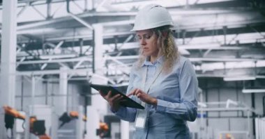 Kendinden emin kadın mühendis, Büyük Üretim Santrali 'nde Otomatik Üretim Denetlerken Dijital Tablet İşletiyor. Smart Factory, Endüstriyel Yenilik, Verimlilik ve Dijital Kontrol Sistemleri.