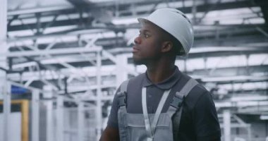 Endüstriyel Erkek Mühendis Modern Fabrika Zemininde Yürüyor ve Otomatik Üretim Hatları ve Robotik Ekipmanlar, Çalışma Akımı Verimliliği ve Akıllı Üretim Sürecini İzliyor.