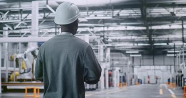 Afrika-Amerikalı Erkek Teknik Müdürü Modern Endüstriyel Tesisin Büyük Ölçekli Araştırmaları. Üst Yönetim ve Büyük Ölçekli Endüstriyel Proje Yönetimi Konsepti. Arka Görünüm.