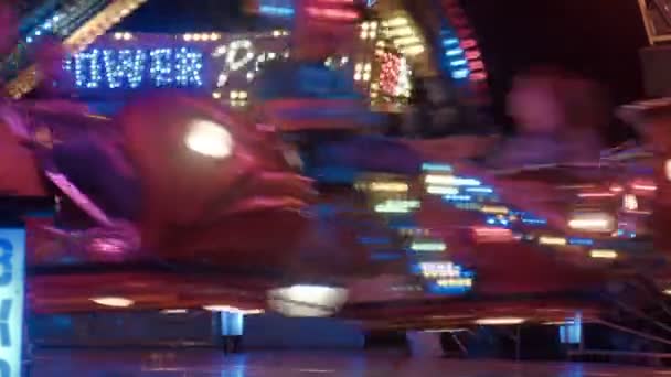 A rotunda giratória à noite em um parque de diversões — Vídeo de Stock