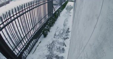 Güvenlik kamerası kayıtları, kar kaldırımından aceleyle inen, omzuna bakan adam. Adam koyu renk gözlük takıyor, siyah şapka takıyor ve Deri Torba Gergin Atmosfer ve Güvenlik Endişesi taşıyor. Arka Görünüm.