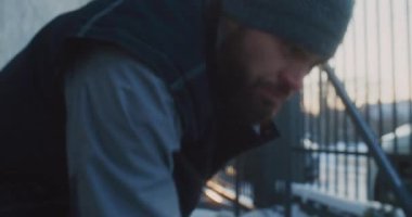 Fasulye Giyen Sakallı Adam ve İşçi Yeleği Giyen Adam Modern Metal Çitin Yanındaki Elle Kar Kaldırıyor. Mülk İkametgahı 'nda Erkek Kış Artırması Yapıyor. Rutin Ev Bakımı, Mevsimsel Bakım.