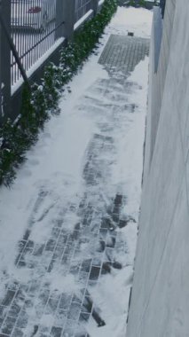 Sakallı Adam, günlük kıyafetlerini giymiş, temiz bir yolda yürüyor, dışarıdaki güvenlik kameralarını görüntülüyor. Her gün Yaya Hareketi, Kış Koşulları, Yerleşim Güvenliği İzleme. Dikey Çekim.