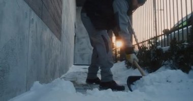 Kış Hizmeti İşçisi, İkamet Binasının yanındaki Karlı Yol 'dan Karı Temizledi. Kar Kürekli Adam, Buz Gibi Yerde Botlar, Güvenli Erişim İçin Rutin Soğuk Hava İşçi Partisi. Kış Rutini Konsepti.