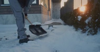 Yetişkin Erkek İşçi Çağdaş Bina 'nın yakınındaki Kar Küreğiyle Kaldırarak ve Fırlatarak Fiziksel Emek Gösteriyor. Soğuk Kış Gününde Çaba, Hareket ve Sorumlu Arka Bahçe Bakımı Konsepti.