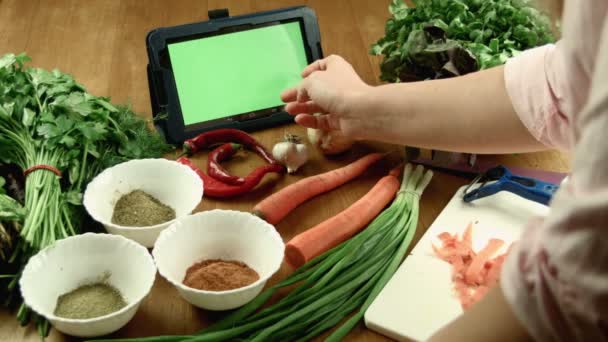 Žena uvaří jídlo a sleduje recept v tabletu — Stock video