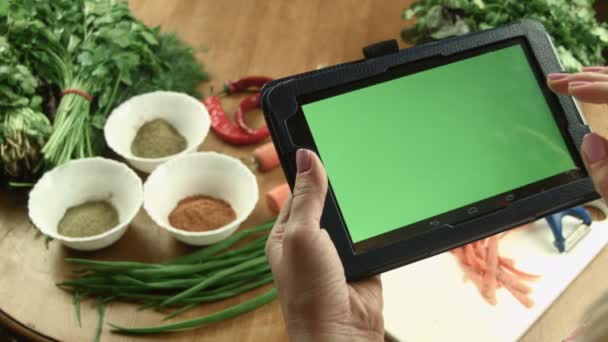 La mujer cocina la comida y observa la receta en la tableta — Vídeos de Stock