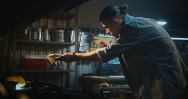 Kaldırılmış Başlıklı Altında Duran Tamirci, Dipstick 'i ve Motor Yağı Seviyesini Odaklanmış Hassasiyetle İnceledi. İnsan Kayganlaştırıcı ve Güvenilir Performans Sağlar. Koruyucu Bakım Uygulaması.