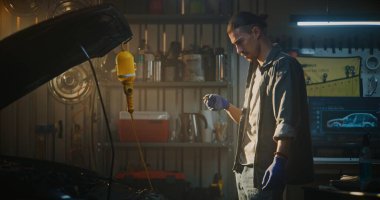 Adam açık motor bölümüne eğiliyor ve yağ çubuğu kontrol seviyesini çekiyor, Temizlemeden ve tekrar yerleştirmeden önce işaretleri dikkatle inceliyor. Araç Bakım ve Motor Sağlığına Dikkat kavramı.