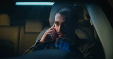 Genç Erkek Sürücü Telefonun İçinde Otururken Şiddetli Tartışıyor. Genç adam sesini yükseltiyor, belli ki yakın biriyle hararetli bir tartışmaya girmiş. İlişki Çakışması ve Kişisel Stres kavramı.