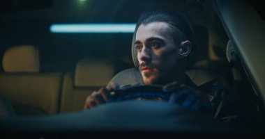 Genç adam arabaya biner ve sürüşe hazırlanır. Erkek, dikiz aynasını ayarlar, emniyet kemerini takar, çıkış parkından önce etrafı kolaçan eder. Sorumlu Sürüş Alışkanlıkları, Güvenlik Bilinci.