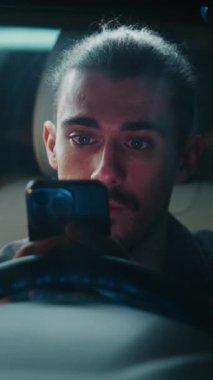 Park Arabası, Erkek Sürücü Çalışmaları Telefon Ekranı, Yavaş Besteleme Mübadelesi. Adam Dijital Mesajla Açılan Kişisel ya da Profesyonel Tartışmaya Odaklandı. Dikey Çekim.