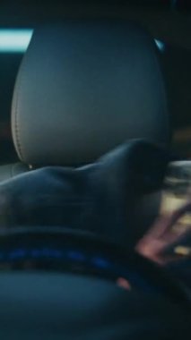 Genç adam neşeli ruh halinde direksiyonda oturur, akıllı telefondan konuşur ve güler. Rahat Adam Canlı Sohbetten Hoşlanıyor. Pozitif Anlık Modern Şehir Yaşam Tarzı, Mobil İletişim. Dikey Çekim.