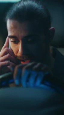 Genç Erkek Sürücü Telefonun İçinde Otururken Şiddetli Tartışıyor. Genç adam sesini yükseltiyor, belli ki yakın biriyle hararetli bir tartışmaya girmiş. İlişki çatışması, kişisel stres. Dikey Çekim.