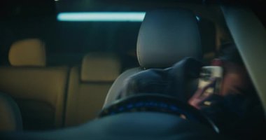 Genç adam neşeli ruh halinde direksiyonda oturur, akıllı telefondan konuşur ve güler. Rahat Adam Canlı Sohbetten Hoşlanıyor. Pozitif Anlık Kavramı Modern Şehir Yaşam Tarzı ve Mobil İletişim.