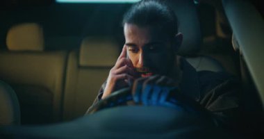 Genç Erkek Sürücü Telefonun İçinde Otururken Şiddetli Tartışıyor. Genç adam sesini yükseltiyor, belli ki yakın biriyle hararetli bir tartışmaya girmiş. İlişki Çakışması ve Kişisel Stres kavramı.