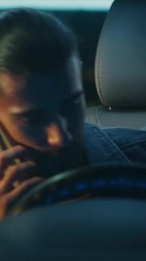 Guy, Smartphone 'da hoş olmayan telefon konuşmalarına devam ederken arabaya biniyor. Direksiyon başında oturmuş, hayal kırıklığıyla konuşuyor. Duygusal Gerilim ve İletişim Zorluğu var. Dikey Çekim.