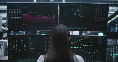 Borsa Verilerini Monitörlerde Analiz Eden Tüccar. Kadın Çoklu Ekranlar Arasında Canlı Finansal Grafiklere Odaklandı. Yüksek Bahisli Borsa Analizi ve Profesyonel Veri İzleme Konsepti.