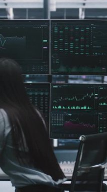 Asyalı Profesyonel Kadın Masada Oturuyor, Kulaklık takıyor ve Kahveyle Takas Yapmaya Hazırlanıyor. Dijital Menkul Kıymetler Borsası 'nda Bağımsız Varlık Yönetimi ve Kadın Liderliği. Dikey Çekim.