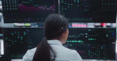 Asyalı Kadın Komisyoncu, Massive Digital Trading Room 'da Gerçek Zaman İndirim İzliyor. Şehrin Kalbindeki Kurumsal Strateji, Kurumsal Yatırım ve Yenilikçi Kurumsal Altyapı kavramı.