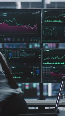 Kadın Dönüşü, Kupa Kahvesi ile Öğle Yemeği Molasından Sonra Çalışıyor ve Modern Borsa Merkezi 'nde yerini alıyor. Dört Monitörle İş İstasyonunda Oturan Kadın Gerçek Zaman Çizelgeleri 'ni gösteriyor. Dikey Çekim.