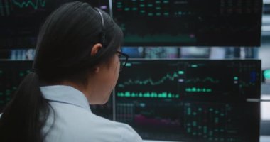 Kadın Uzman, Yenilikçi Dijital Ofiste Dört Büyük Ekranda Piyasa Volatilitesini İzliyor. Yatırım Merkezi, Risk Yönetimi, Modern Borsa Endüstrisinin Yüksek Teknoloji Doğası.