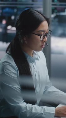 Yenilikçi Çalışma Alanında Asyalı Kadın Oturumları, Ticaret İndekleriyle Dolu Çoklu Görüntü Taraması. Genç bayan klavyeyi veri girişi ve piyasa emirlerini uygulamak için aktif olarak kullanır. Dikey Çekim.