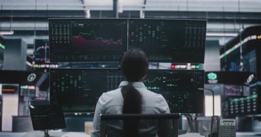 Profesyonel Asyalı Kadın, Geleceğin Değişim Merkezi 'ndeki Yatırımları Yönetiyor. Modern Finansal Endüstride Yenilikçi Dijital Çalışma Alanı ve Büyük Veri Görselleştirmesi.