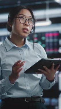 Tablet ve Ekran Analizlerini Eşleştirirken Uzman Danışmanlık Müşteri Kulaklığı. Mobil ve Masaüstü Analizlerinin Fütürist Borsa Merkezinde Stratejik Düşünce ve Bütünleşmesi. Dikey Çekim.