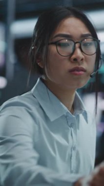 Piyasa Değişiklikleri Üzerine Meslektaşları azarlamak için Asyalı Kadın Denetleyici Telefonu kullanıyor. Ciddi Kadın Ekranlarda Değişen Analizleri Gözlemliyor, Masa Telefonu Açıyor Katı Talimatlar Veriyor. Dikey Çekim.