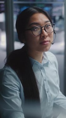 Asyalı Komisyoncu Kadın, Sevdiği Kişiyle Smartphone 'da Karmaşık Çizelge Sohbetleri' ni Analiz Etmekten Bir Anlık Uzaklaştı. Pozitif Duygular ve Dinlendirici Mola, İnsan Tarafı Şirketi Kariyeri. Dikey Çekim.