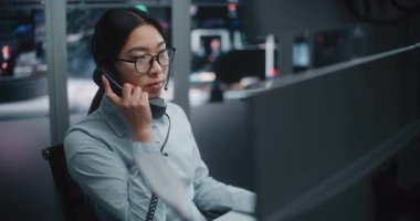 Modern Ticaret Merkezi 'nde Canlı Finansal Verileri İzlerken Profesyonel Asya Borsası Operatörü Sabit hattan konuşuyor. Kadın, Müşterilerle Pazar İşlemleri ve İletişim Yönetimi.