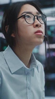 Asyalı İş kadını Modern Borsa Merkezi 'ndeki Multi Monitor Workstation' da çalışıyor. Tarz Gözlüklü Kadın Tüccar Ekran ve Tabletler Üzerinde Gerçek Zamanlı Finansal Verileri İnceledi. Dikey Çekim.