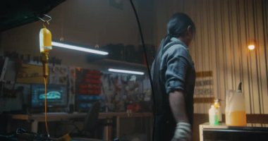 Tulumlu yetenekli Asyalı kadın motor bölümüne araba bakımı için sıvı dolduruyor. Aletlerle Hizalanan Kız, Hassasiyet, Sorumluluk ve Modern Mekanik Profesyonelliği Gösteriyor.