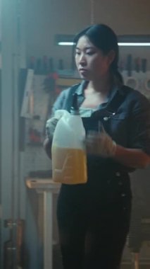 Asyalı Kadın Profesyonel Titizlikle Motor yağını Motor Motor Ambarına dökerek, Tepe Performansını, Kuşatılmış Aletleri ve Ekipmanları Sağlama. Kadın Gücü, Modern Mekanik Endüstri Uzmanı. Dikey Çekim.