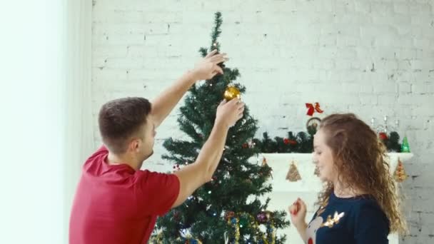 A couple decorate a Christmas tree — Stock Video