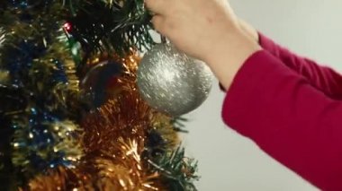 Küçük kız bir Noel ağacı topu üzerinde asılı